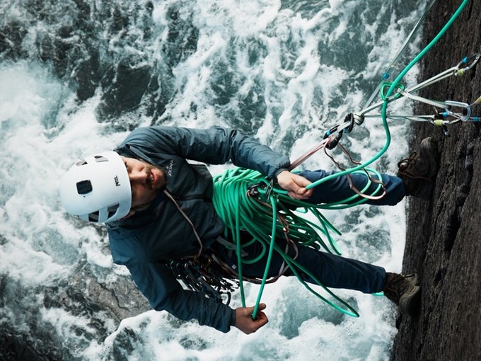 A man rappelling down a mountain.