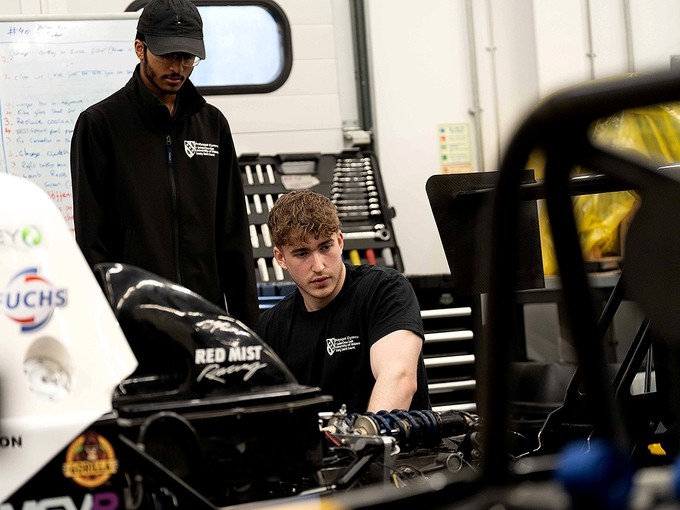 Ragulan and a fellow student examine an engine.
