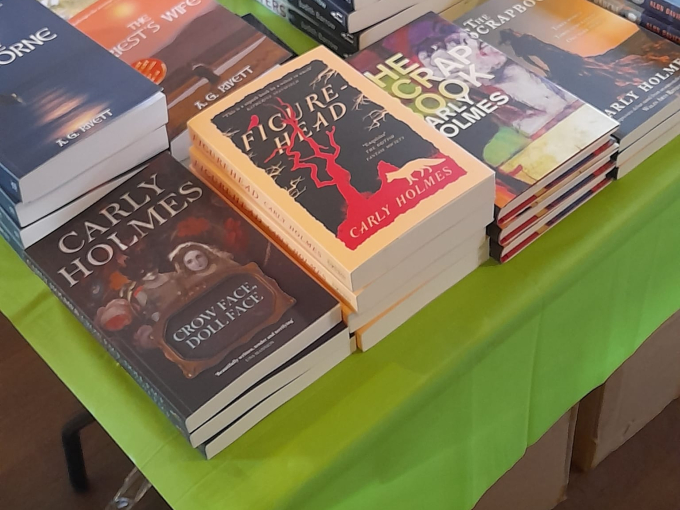 Image of Carly Holmes' books on a table at an event