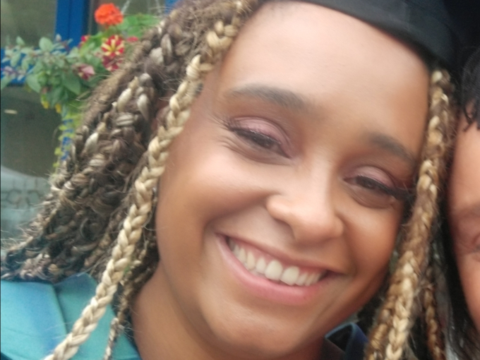 Woman in gown and mortarboard smiling at camera
