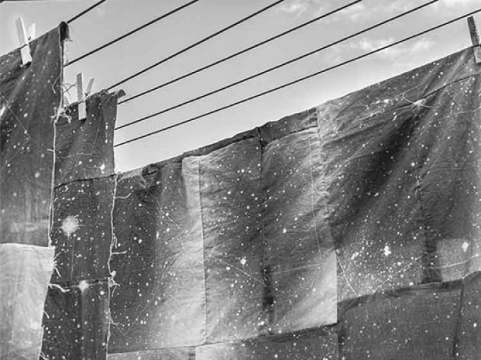 Black and white image of sheets on a line with paint splats