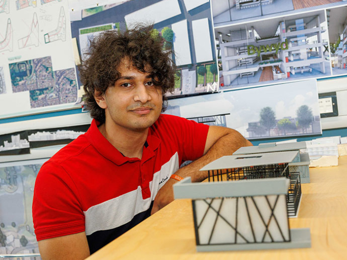 Hashim Izzidien standing in front of work