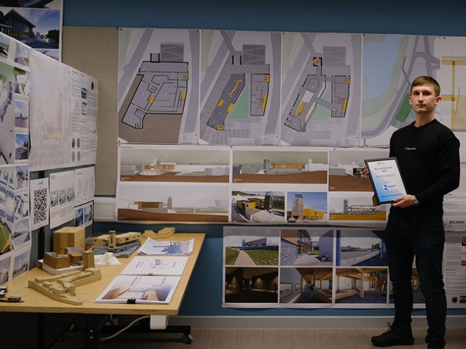Cole Evans standing in front of his Architecture display