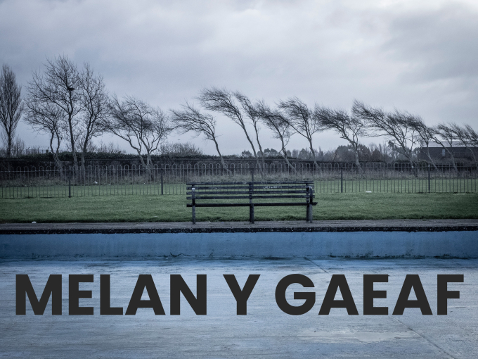 Mainc wag ar ddiwrnod llwm a gwyntog, gyda geiriau 'Melan y Gaeaf'