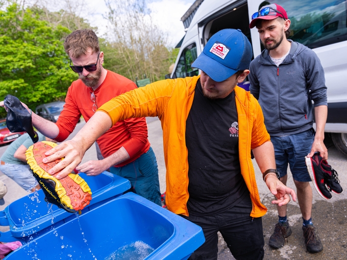 student washing trainers outside