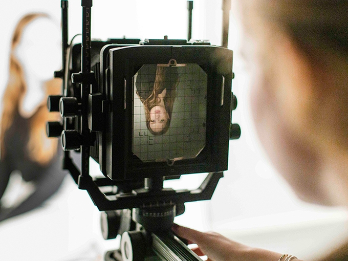 photography stores camera pointing to a student