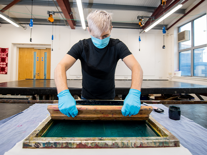 Screen printing workshop student using equipment 