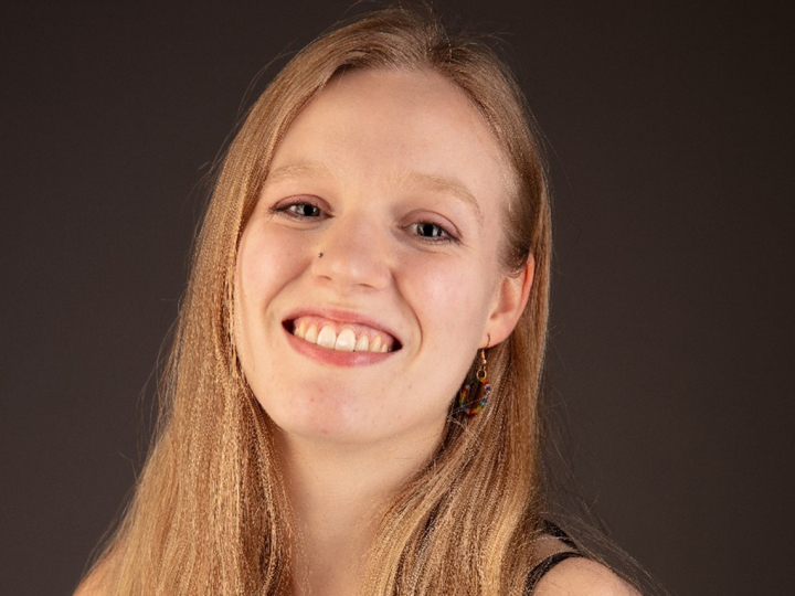 Jojo Bishop smiles for the camera in a studio photo. 