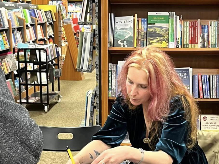 Image of Carly Holmes signing one of her books