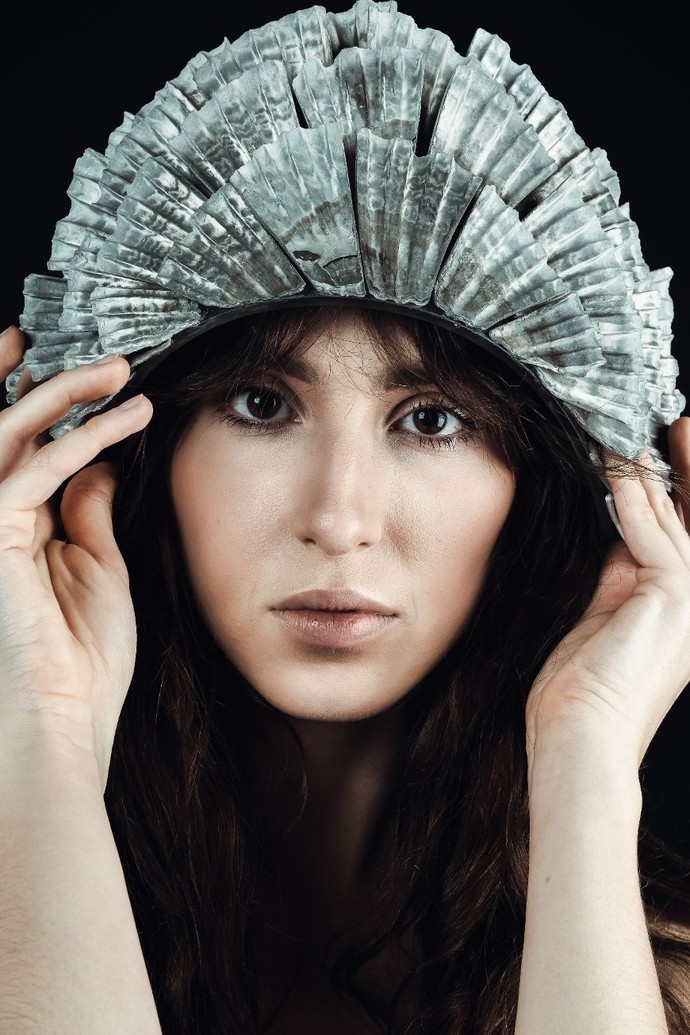 Model yn gwisgo penaddurn o gragen gwyrddlas golau a gwydr, wedi’i ddylunio gan Molly Ashton.