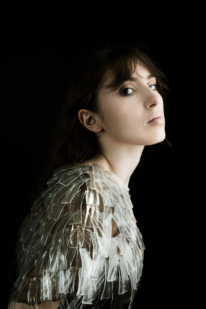 A model wearing a piece of glass body jewellery, which covers her shoulders and chest.