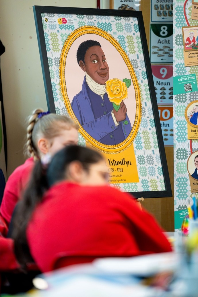 children in the foreground with one of Brethyn Cyru's characters being showcased on a display board