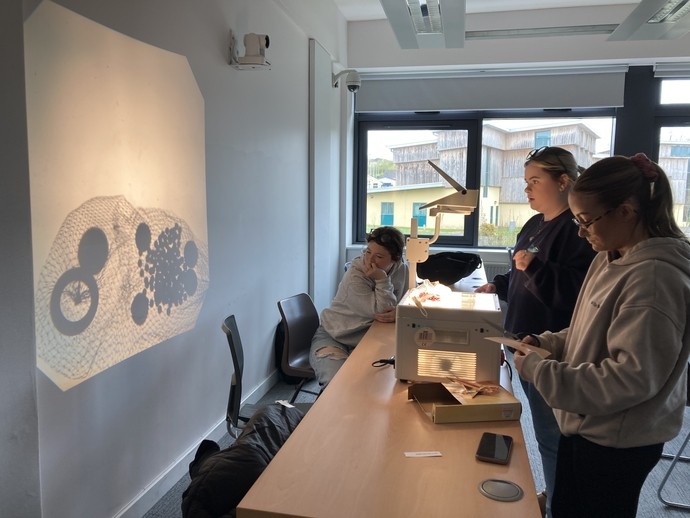 Students working on a craft workshop using an overhead projector
