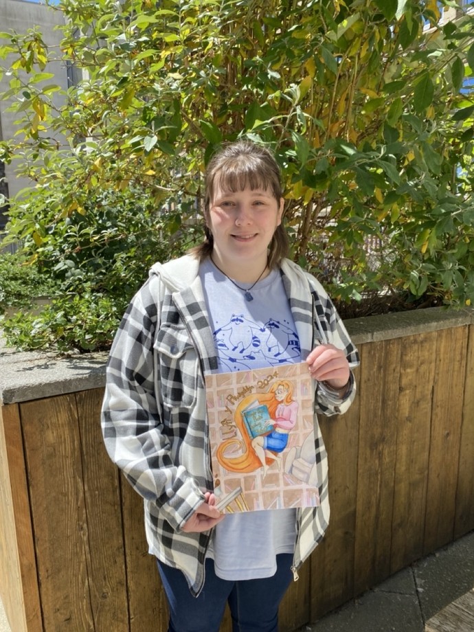 Nia Hopkins holding her comission for Golwg360 Barn y Bobl's prize