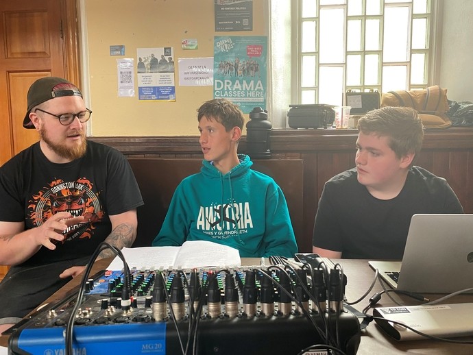 A photo of Theatre members receiving tech training from a profressional