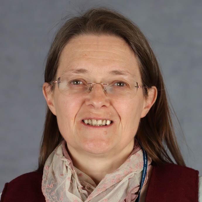 Llun stiwdio o’r Athro Heather Williams: mae’n gwisgo sbectol ac mae ganddi wallt brown hyd ei hysgwyddau.   