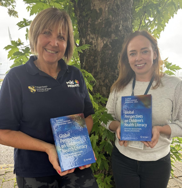Nalda and Kate holding a copy each of the book 