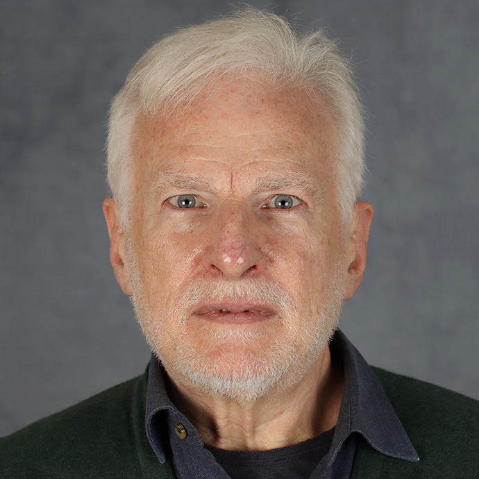 Professor John Koch looks directly at the camera in a studio shot. 