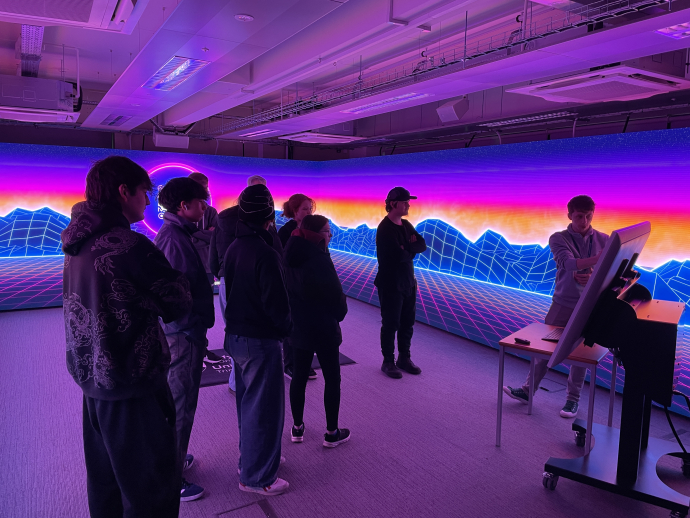 a group of students looking at the Immersive Room