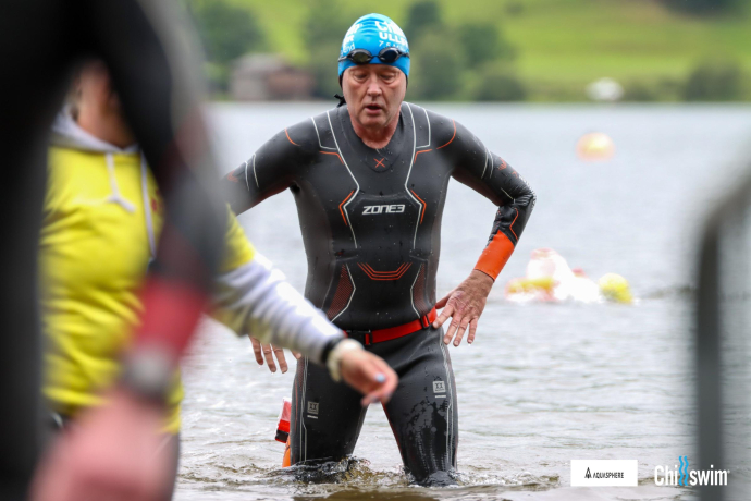Paul Osborne in wet suit standing in lake