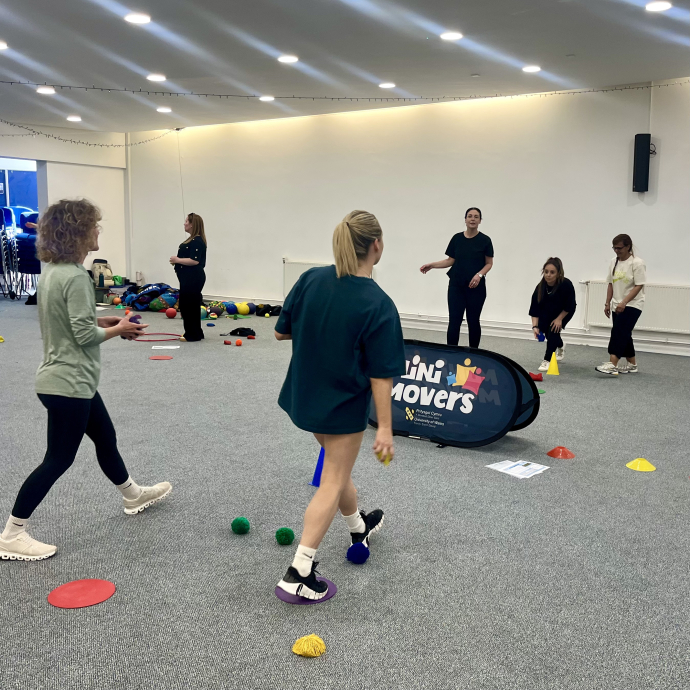 a group of teacher on a training course throwing bean bags to each other