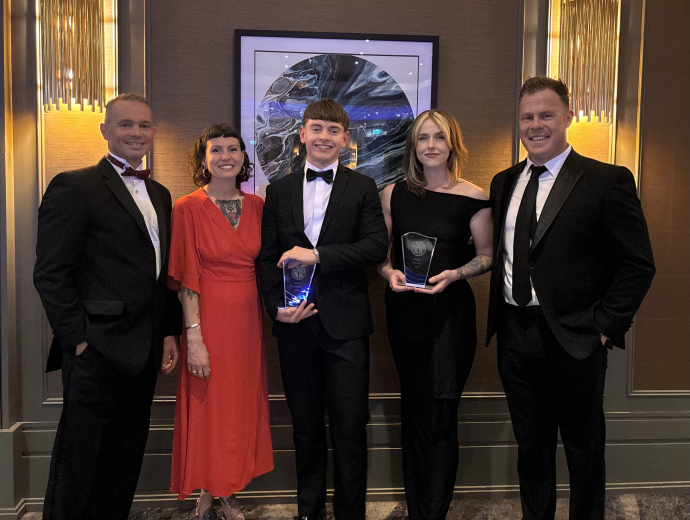a group photo of Geraint Forster with students holding the award at the Ceremony