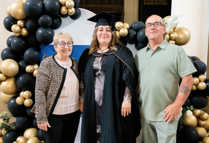 Maria D'Angelo with her parents at her graduation ceremony