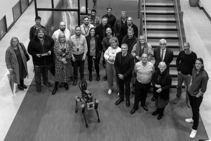 Image of people standing in front of staircase with robot dog