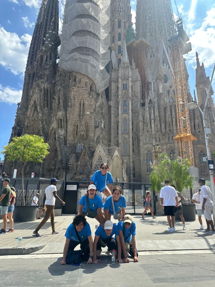 A group of students creating a pyramid shape in front of the Sagrada Familia in Barcelona