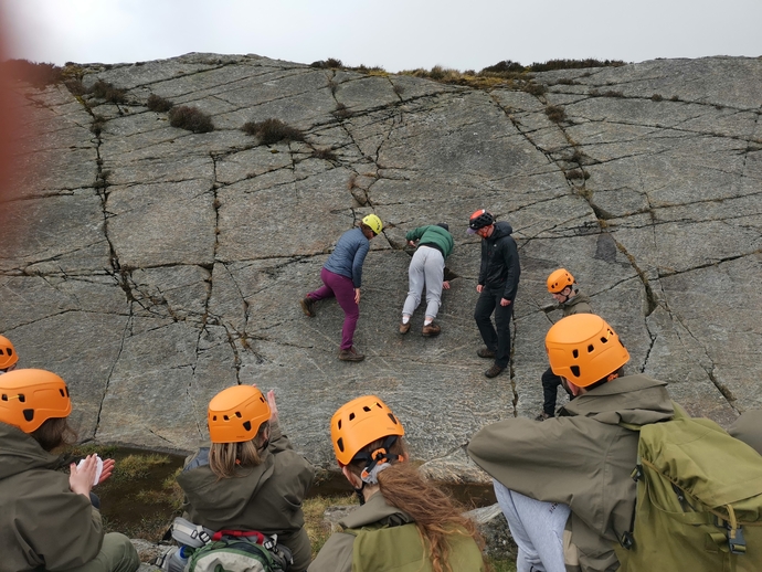 a group of young people rock climbing