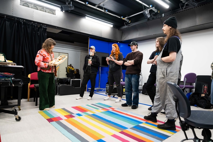 Angharad playing the crwth with students around