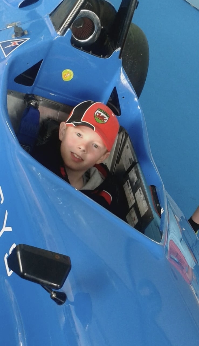 Aron Evans as a child sitting in a race car