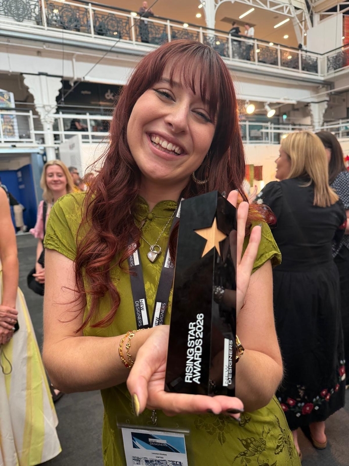 A happy smiling and proud student, holding an award in her hands.