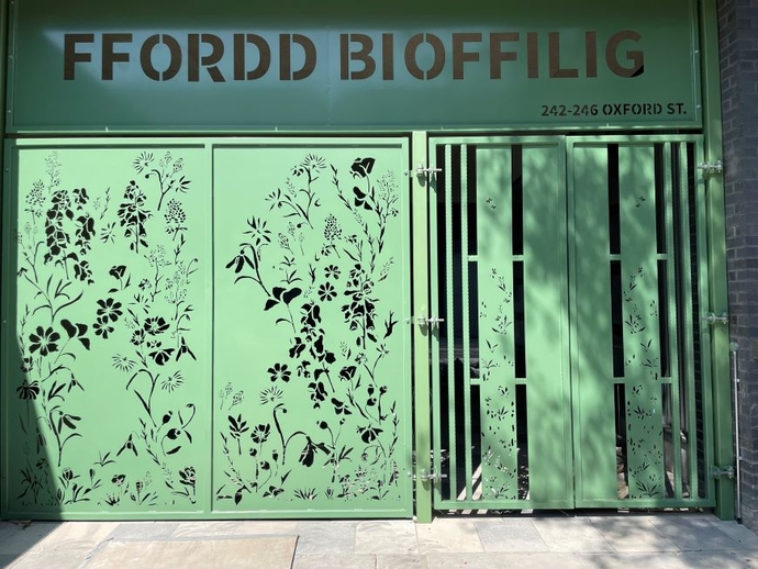 A green door way with artwork photographed partially in the shade.