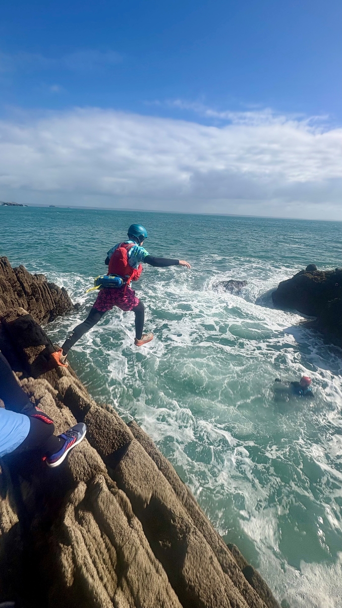 Student jumping into the sea whilst coasteering