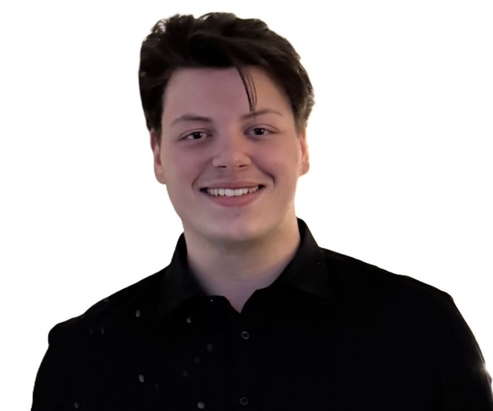 A smiling student dressed in a dark coloured shirt.
