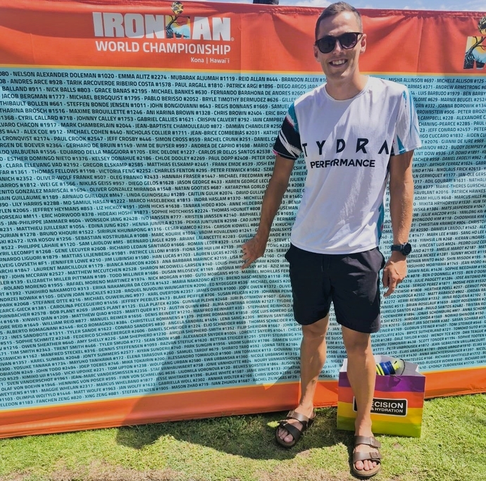 Guto Morgans pointing at his name written on a banner saying 'Ironman World Championship"
