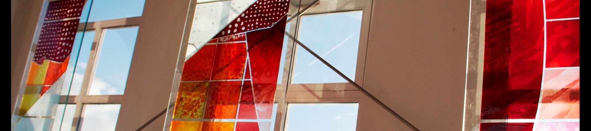 Stain glass panels in front of windows catch the light.