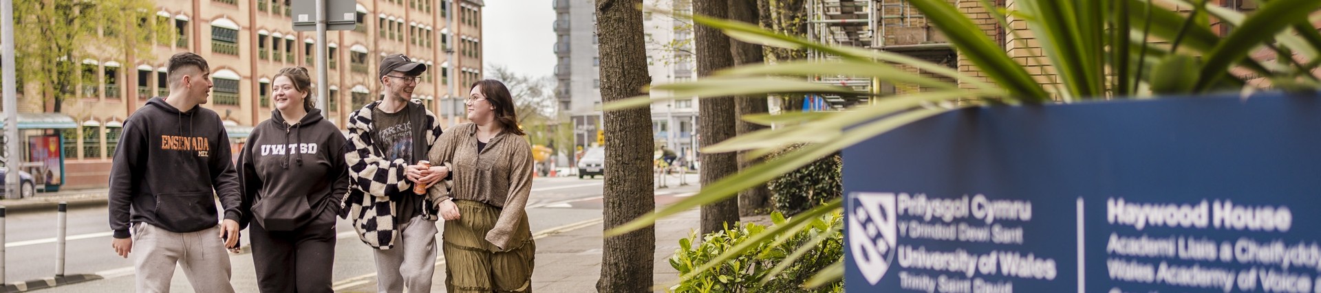 Four students walking outside Cardiff campus 