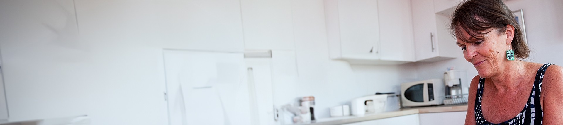 Person sitting down with kitchen appliances in the background