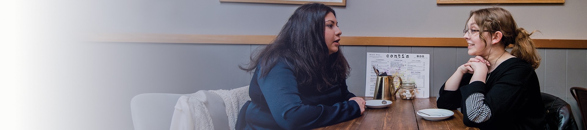 Two students in discussion at a coffee shop 