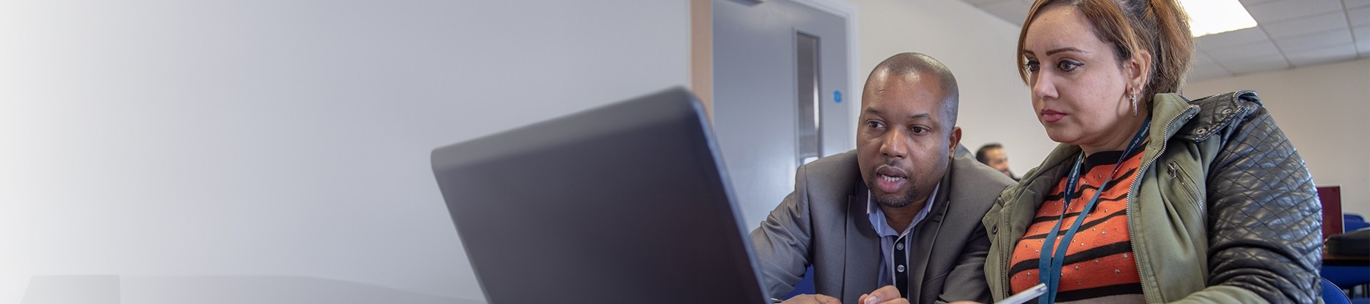 Staff member and student looking at a laptop