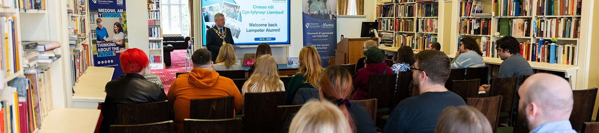 people sitting down at an Alumni presentation