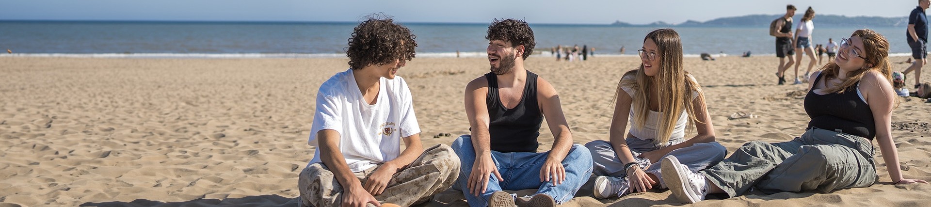 Students sitting on the beach