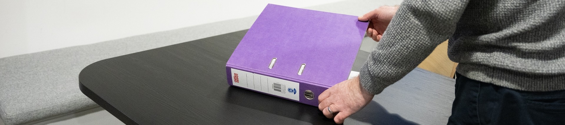 Person opening a purple ring binder 