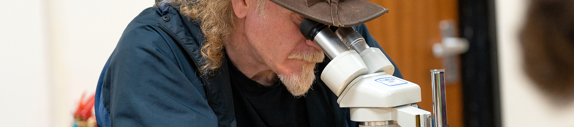 Mature Student Looking Through Microscope