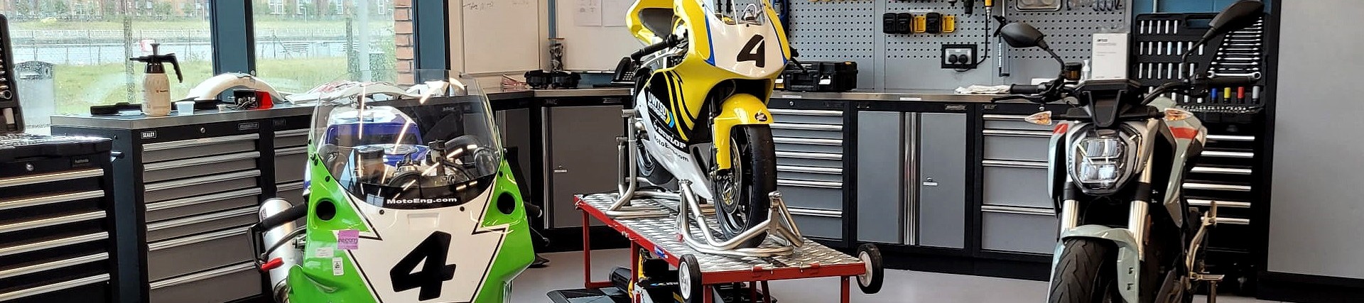 Three motorcycles in a workshop.