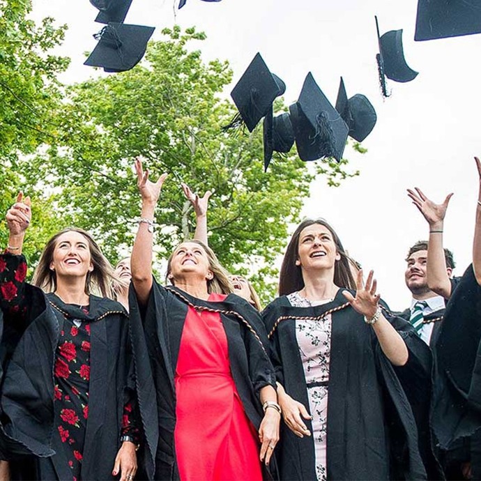 a group of students throwing hats in the air