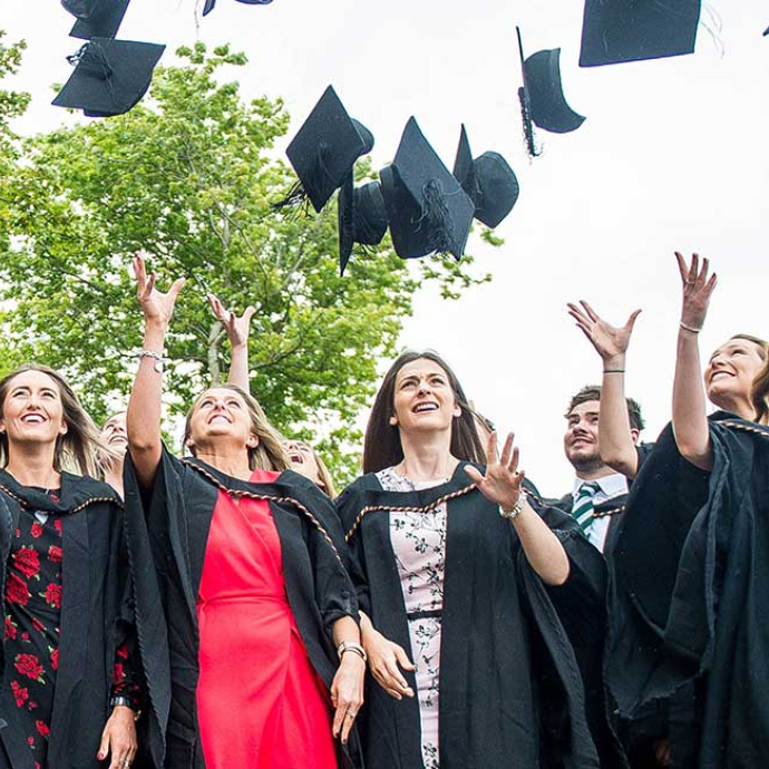 a group of students throwing hats in the air