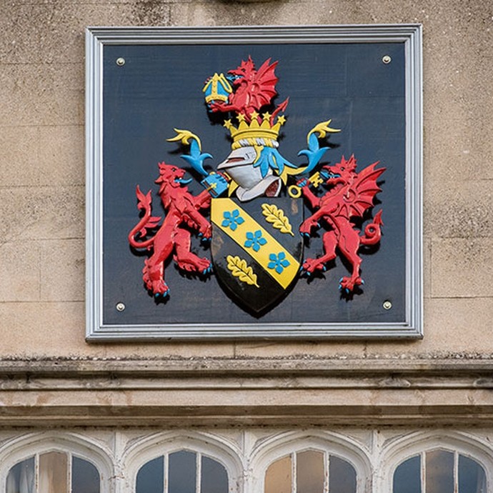Brightly painted UWTSD coat-of-arms on the wall of the college in Lampeter.